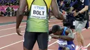 Pelari AS, Justin Gatlin berlutut di hadapan Usain Bolt usai menjadi juara pada lomba lari 100 meter Kejuaraan Dunia Atletik 2017 di Stadion London, Minggu (6/8). Itu dilakukan usai Gatlin dicemooh para penonton karena menjadi juara (AP/Matthias Schrader)