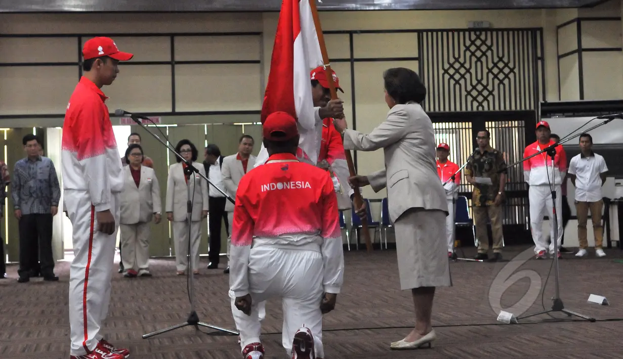 Ketua KOI, Rita Subowo (kanan) bersiap menyerahkan Bendera Merah Putih kepada CDM kontingen Indonesia, Taufik Hidayat (kiri) saat acara Pengukuhan dan Pelepasan Kontingen untuk SEA Games 2015 di Senayan, Jakarta (25/5/2015). (Liputan6.com/Andrian M Tunay)