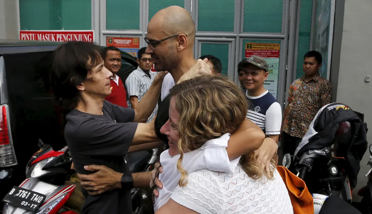 Ferdinant Tjiong (kiri) dan Neil Bantleman ditemani para istri berpelukan di depan penjara Cipinang, Jakarta (14/8/2015). Dua guru Jakarta International School (JIS) Ferdinant dan Neil diputus bebas oleh Pengadilan Tinggi Jakarta. (REUTERS/Beawiharta)