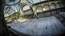 Orang-orang  berseluncur di arena ice skating di bawah kubah kaca mewah legendaris, Grand Palais, Paris, Senin (17/12). Tempat seluas 1.800 meter persegi ini menjadi arena ice skating sementara terbesar di Prancis. (STEPHANE DE SAKUTIN / AFP)