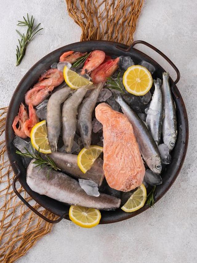 Seafood mentah yang terdiri dari salmon, ikan, dan udang disajikan di atas sebuah wajan saji (Foto Dok: Freepik/freepik)