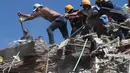 Warga dan petugas penyelamat mencari di antara puing-puing setelah gempa bumi melanda Cali, Kolombia, pada hari Senin, 10 Agustus 2026. (Foto AP/Santiago Saldarriaga)