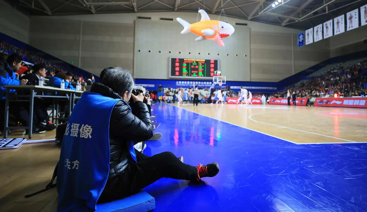Fotografer Hong Nanli mengambil gambar selama pertandingan bola basket di Shanghai, China (16/1). Di usia senjanya, nenek Hong Nanli dikenal sebagai salah satu fotografer legendaris di China. (AFP Photo/China Out)