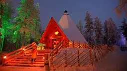 Pengunjung memasuki sebuah restoran di Desa Sinterklas atau Santa Claus Village, di Lingkar Arktik, Finlandia, 15 Desember 2016. Kawasan yang tertutup salju pada musim dingin ini makin menguatkan suasana 'White Christmas'. (REUTERS/Pawel Kopczynski)