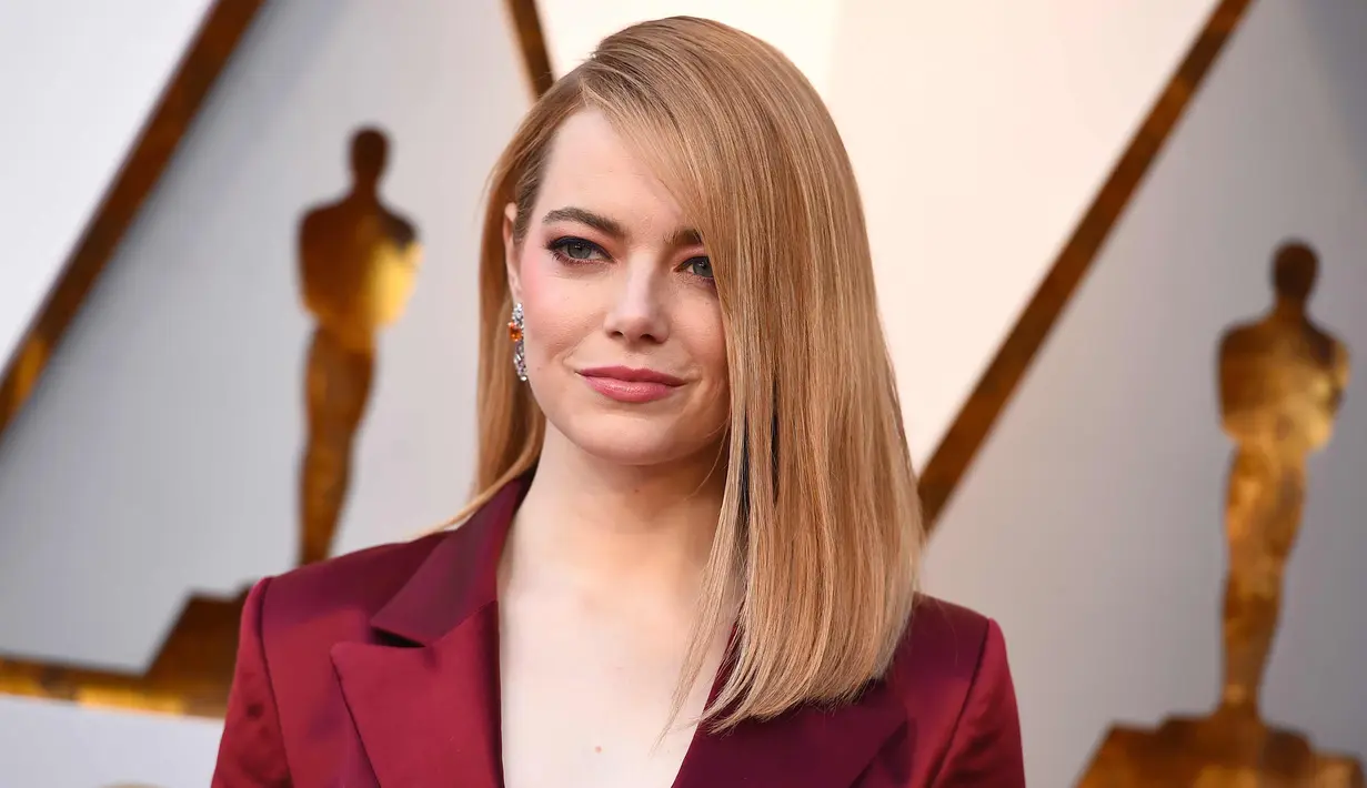 Aktris Emma Stone berpose saat tiba menghadiri acara Piala Oscar 2018 di Dolby Theatre di Los Angeles, AS (4/3). Emma Stone tampil cantik dengan busana berwarna merah hati. (Photo by Jordan Strauss/Invision/AP)