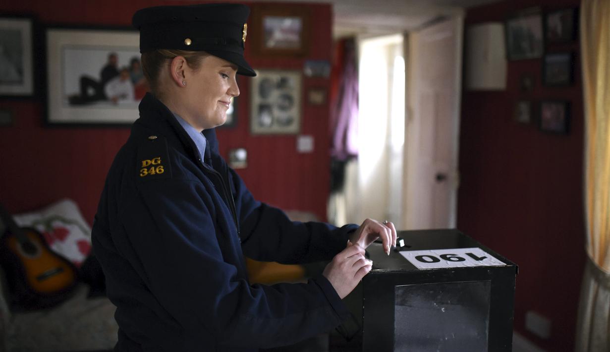 Margaret Byrne mempersiapkan tempat pemungutan suara (TPS) di rumah warga di pulau Innisfree, Irlandia, (25/2). Pulau terpencil ini hanya terdapat empat orang yang memiliki hak pilih. (REUTERS/Clodagh Kilcoyne)