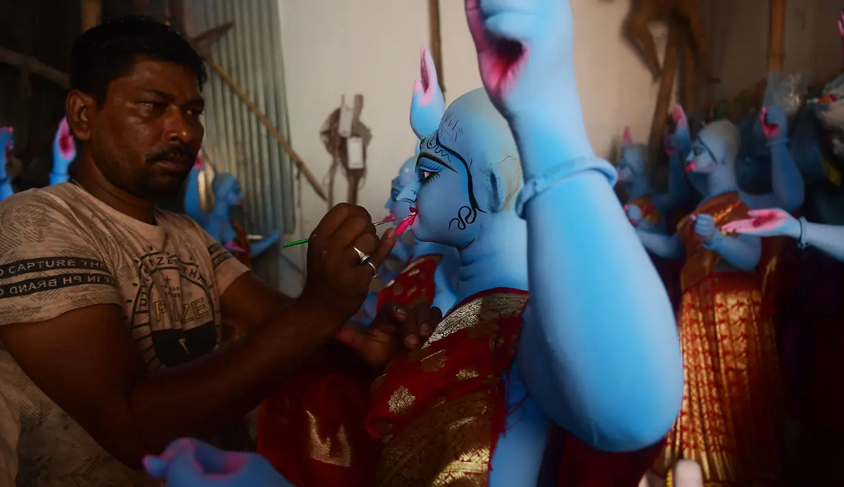 Seorang pemahat mengecat patung-patung Dewi Kali menjelang festival Diwali di Agartala, ibu kota Negara Bagian Tripura, India timur laut, pada 12 November 2020. (Xinhua/Stringer)