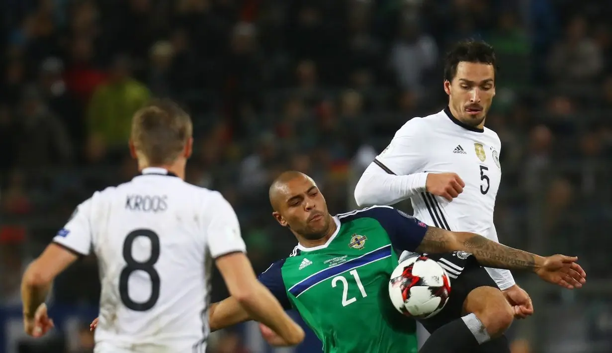 Striker Jerman, Mats Hummels (kanan), berebut bola dengan pemain Irlandia Utara, Josh Magennis, pada laga Grup C Kualifikasi Piala Dunia 2018 zona Eropa, di HDI-Arena, Hanover, Rabu (12/10/2016) dini hari WIB. (Reuters/Kai Pfaffenbach)