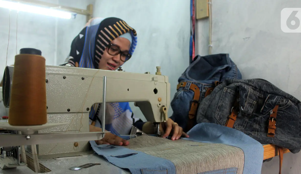 Perajin Risma Eljundi menyelesaikan pembuatan tas dari bahan celana jeans bekas di Legok, Tangerang, Banten, Senin (11/11/2019). Tas berbahan jeans dijual dengan harga Rp 150 ribu hingga Rp 250 ribu. (merdeka.com/Arie Basuki)