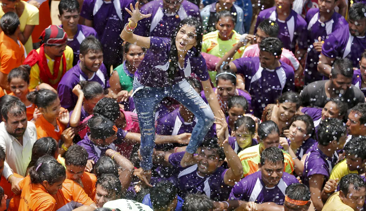 Seorang umat Hindu mencoba untuk menngambil dan memecahkan dahi-handi (pot yang terbuat dari tanah liat) pada Festival Janmashtami di Mumbai, India, 6 September 2015. Festival ini menandai kelahiran dewa Krishna (REUTERS/Danish Siddiqui)