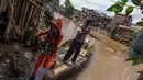 Seorang warga terlihat turun dari perahu eretan yang terbuat dari kayu. (Liputan6.com/Faizal Fanani)