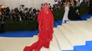 Katy Perry saat menghadiri Met Gala 2017 di Metropolitan Museum of Art, New York (1/5). Dalam ajang ini banyak selebritas yang menggunakan gaun-gaun unik, seperti Katy yang mengenakan gaun serba merah dengan atribut kepala. (AFP Photo/Angela Weiss)