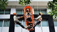 Mahasiswa mengikuti simulasi Vertical Rescue atau evakuasi vertikal selama latihan gempa bumi dan bencana di Universitas Syiah Kuala, Banda Aceh pada Selasa 21 Oktober 2025. (CHAIDEER MAHYUDDIN/AFP)