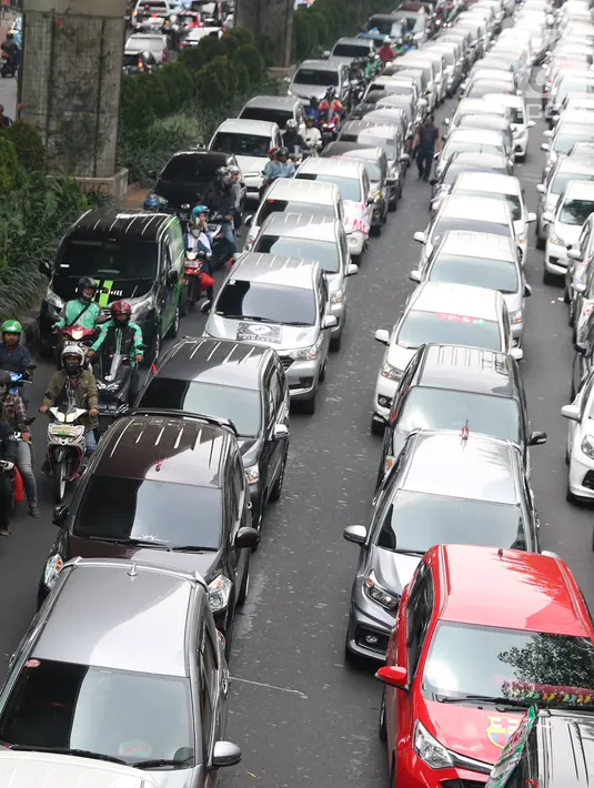 Salah satu pengendara motor mencoba menembus jejeran kendaraan taksi online yang berjejer di jalan Iskandarsyah menuju Terminal Blok M, Jakarta, Selasa (25/9). Mereka berunjuk rasa di depan Kantor GO-JEK Indonesia. (Liputan6.com/Helmi Fithriansyah)