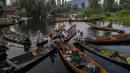 Laki-laki Kashmir menjual produk mereka di pasar sayur terapung di Danau Dal, Srinagar, Kashmir, India, Sabtu (7/8/2021). Berdagang sayuran menjadi salah satu sumber pendapatan utama penghuni Danau Dal. (AP Photo/Dar Yasin)