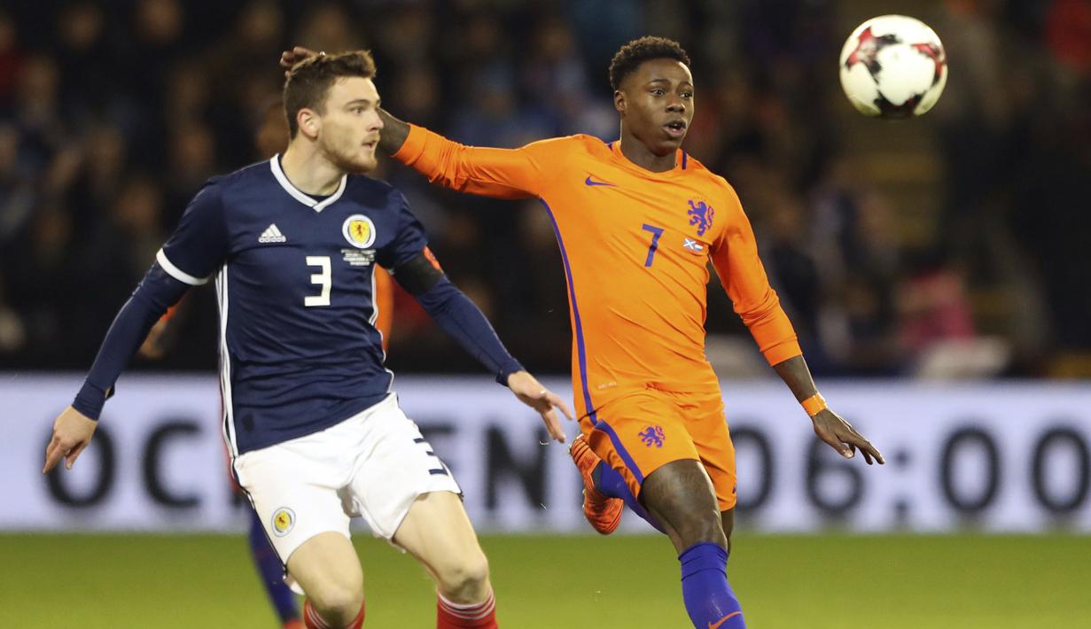Pemain Skotlandia, Andrew Robertson (kiri) berebut bola dengan pemain Belanda, Quincy Promes pada laga persahabatan di Pittodrie, Aberdeen, Skotlandia (9/11/2017). Belanda menang 1-0. (Andrew Milligan/PA via AP)