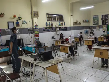 Siswa mengikuti pembelajaran tatap muka (PTM) di sebuah sekolah di Surabaya, Jawa Timur, Senin (6/9/2021). Pemerintah kembali membuka sekolah di tengah pandemi COVID-19. (JUNI KRISWANTO/AFP)