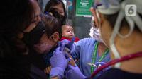 Petugas memeriksa kesehatan serta imunisasi pasien anak di RSIA Bunda, Jakarta, Jumat (18/3/2022). Pemeriksaan dilakukan drive thru guna memberi rasa aman orangtua, khususnya ibu yang ingin melaksanakan imunisasi serta pemeriksaan nonpenyakit di tengah pandemi COVID-19. (Liputan6.com/Faizal Fanani)