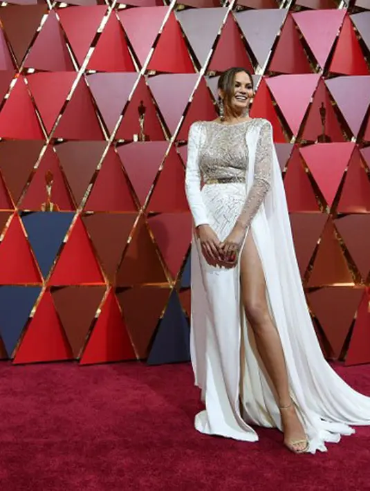 Bukan Chrissy Teigen kalau tak memamerkan keseksian tubuhnya. Hadir di panggung Oscar, Teigen memakai dress putih menjuntai dengan belahan yang memerlihatkan bagian kakinya yang jenjang. (AFP/Bintang.com)