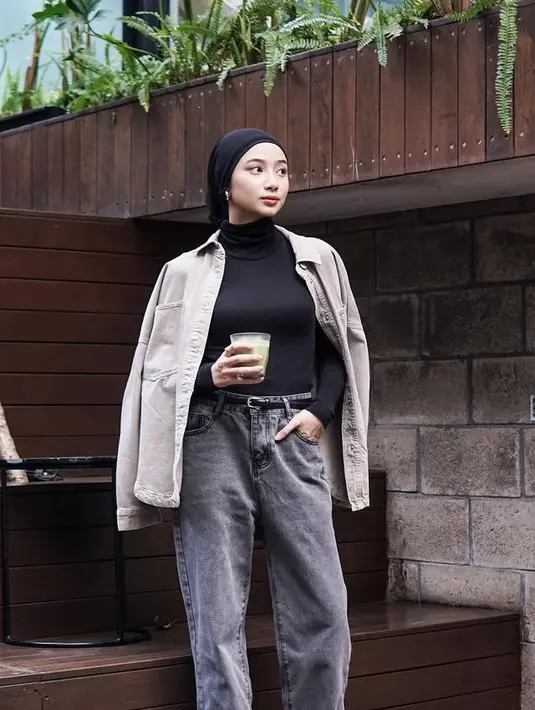 Bergaya layering dengan inner turtleneck hitam senada dengan kerudung turban dan belt mininya. Dipadukan outer kemeja oversize abu-abu dan celana denim panjang. [@ansellmaputri]