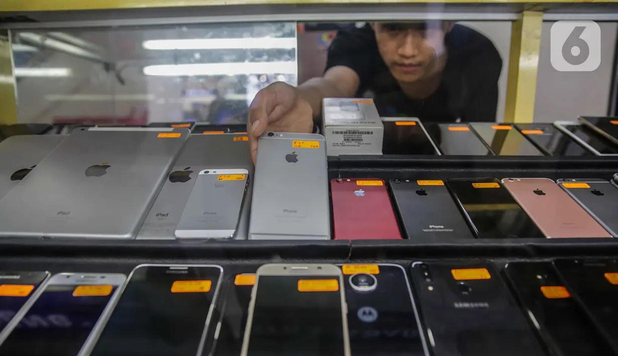 Pedagang merapikan sejumlah handphone bekas yang dijual di ITC Roxy Mas, Jakarta, Selasa (26/11/2019). Pemerintah melalui Kemendag, Kemenperin, dan Kemenkominfo menerbitkan regulasi pemblokiran ponsel ilegal melalui nomor IMEI yang disahkan pada 18 Oktober 2019. (Liputan6.com/Faizal Fanani)