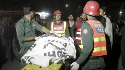 Petugas membawa korban tewas ledakan bom di area parkir taman Gulshan e Iqbal Park di Lahore, Pakistan, (27/3/2016). Ledakan terjadi saat banyak anak-anak dan orangtua sedang berada di area tersebut. (REUTERS / Mohsin Raza)