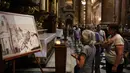 Para wanita melihat lukisan yang menggambarkan Paus Fransiskus di Basilika San Jose de Flores di Buenos Aires pada 23 Februari 2025. (Emiliano Lasalvia/AFP)