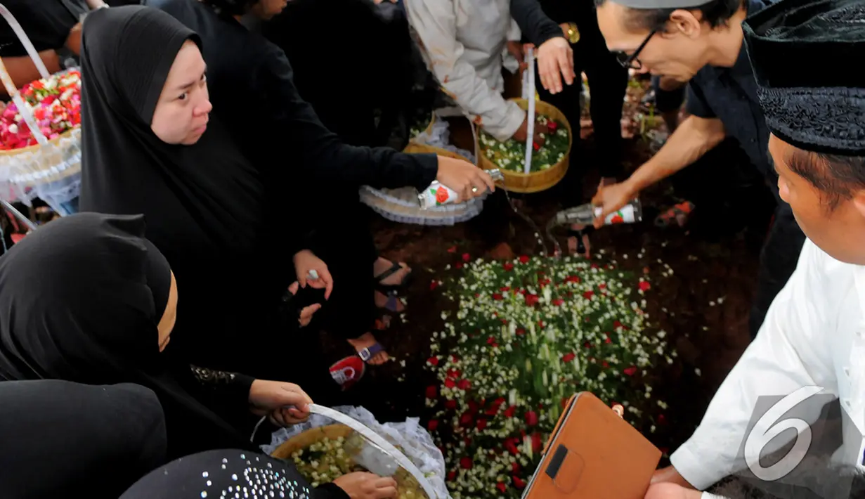Usai dikuburkan, Melly dan keluarga menaburkan bunga di makam ibunya, TPU Tanah Kusir, Bintaro, Senin (12/1/2015). (Liputan6.com/Faisal R Syam)