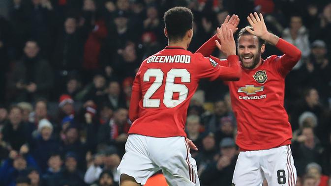 Pemain Manchester United, Juan Mata, merayakan gol yang dicetak Mason Greenwood ke gawang AZ Alkmaar pada laga Liga Europa di Stadion Old Trafford, Manchester, Rabu (12/12). MU menang 4-0 atas AZ. (AFP/Lindsey Parnaby)