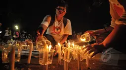 Seorang aktivis menyalakan lilin saat aksi damai untuk save Mary Jane di depan Istana Merdeka, Jakarta, Minggu (26/4/2015). Aksi tersebut meminta eksekusi atas Mary Jane dibatalkan. (Liputan6.com/Faial Fanani)
