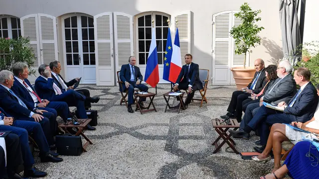 Sambil Berlutut, Putin Beri Bunga kepada Istri Presiden Prancis