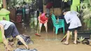 Warga membersihkan lumpur sisa banjir di halaman rumahnya di perumahan Ciledug Indah, Tangerang Senin (21/2/2021). Banjir yang menggenangi perumahan tersebut membuat warga mengalami kerugian cukup besar karena barang-barang berharga mereka rusak parah. (Liputan6.com/Angga Yuniar)