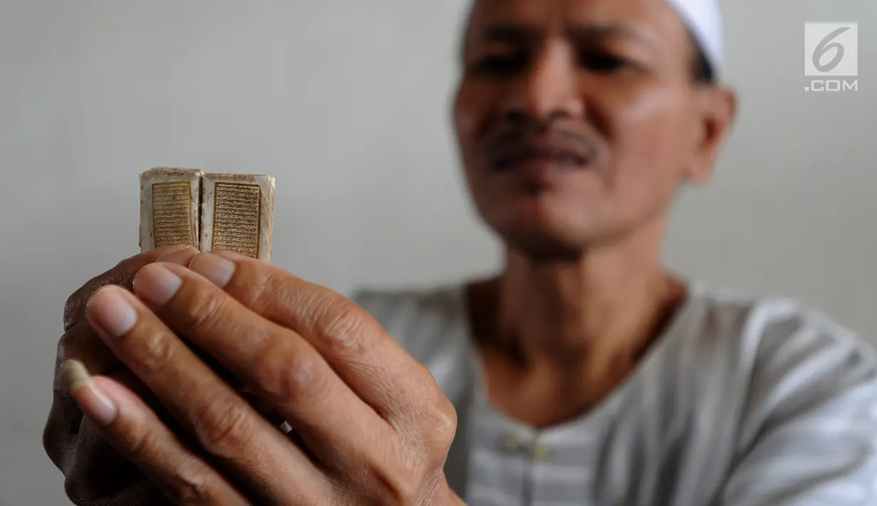 Kyai Tubagus Muhammad Tamyiz mengaji dengan  Al Quran mini bertinta emas saat mengajar  para santri  memaknai Kitab Kuning' di Pondok Pesantren Almiizan, Kabupaten Bogor, Jawa Barat, Senin, (20/5/2019). Al Quran mini ini berukuran 10 mm x 10 mm. (merdeka.com/Arie Basuki)