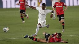Pemain Real Madrid, Vinicius Junior, berusaha melewati pemain Real Mallorca pada laga La Liga di Stadion Alfredo Di Stefano, Kamis (25/6/2020). Real Madrid menang 2-0 atas Real Mallorca. (AP/Bernat Armangue)