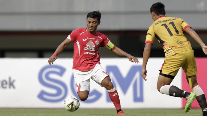 Gelandang Semen Padang, Irsyad Maulana, berusaha melewati bek Mitra Kukar, Roni Fatahilah, pada laga Piala Presiden 2019 di Stadion Patriot, Bekasi, Kamis (14/3). Padang menang 2-0 atas Mitra. (Bola.com/Yoppy Renato)