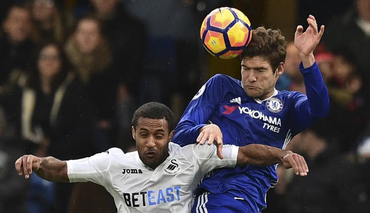 Bek Chelsea, Marcos Alonso, duel udara dengan gelandang Swansea, Wayne Routledge. Dalam laga ini The Blues memiliki sembilan kali kesempatan mencetak gol, sedangkan Swansea hanya sekali. (AFP/Glyn Kirk)