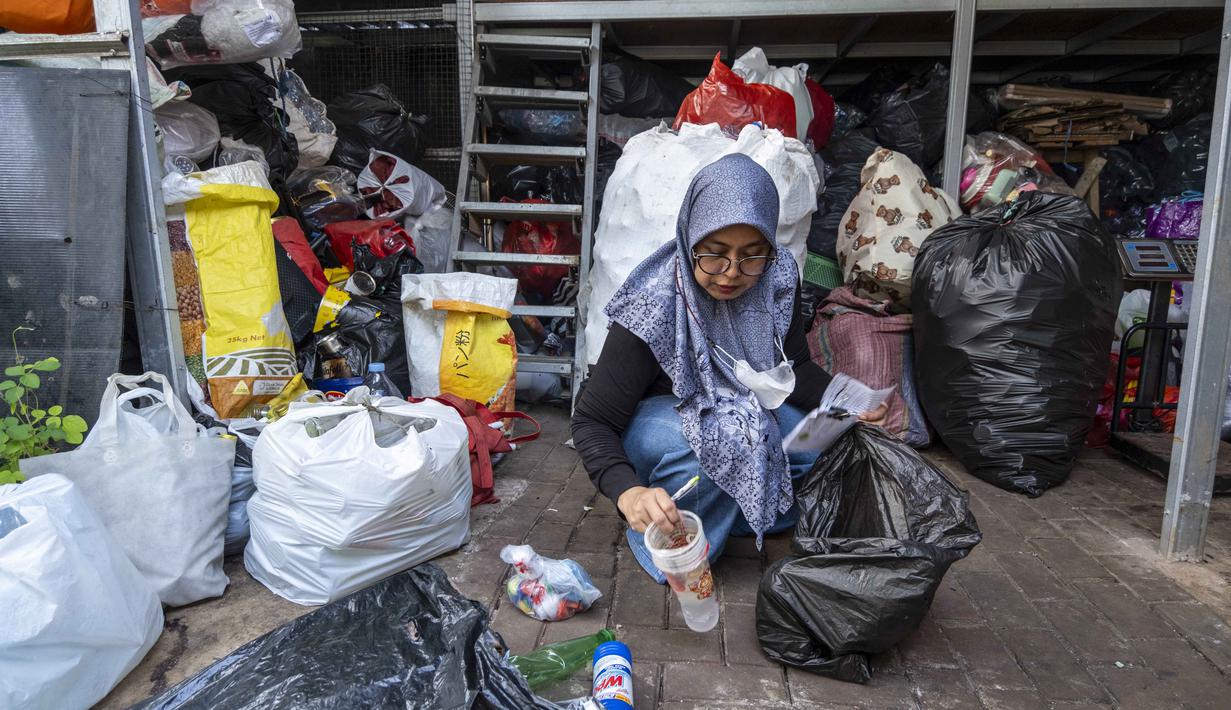 Seorang relawan bank sampah memilah sampah anorganik rumah tangga, baik berupa karton maupun botol plastik, Jakarta, Kamis 4 Juni 2026, sebagai bagian dari instruksi Pemprov DKI yang mewajibkan warga memilih dan memilah sampah untuk mengurangi beban sampah yang semakin menumpuk di ibu kota. (BAY ISMOYO/AFP)