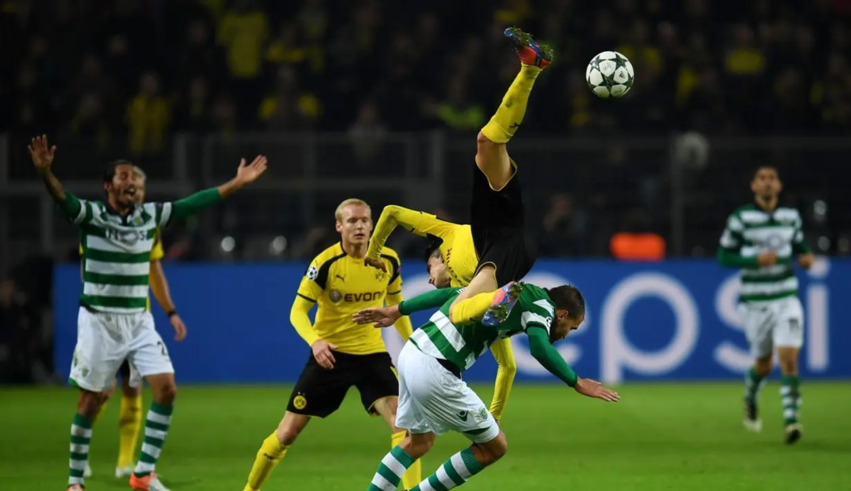 Pemain Borussia Dortmund, Marc Bartra, terjungkal saat berebut bola dengan pemain Sporting CP, Bas Dost, dalam laga Grup F Liga Champions di Signal Iduna Park, Rabu (2/11/2016) waktu setempat. (AFP/Patrik Stollarz)