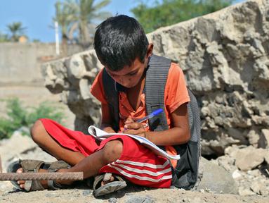 Anak-anak Yaman menghadiri kelas di luar ruangan sebuah sekolah yang rusak parah pada hari pertama tahun ajaran baru di provinsi barat Yaman yang dilanda perang Hodeida, Senin (17/10/2022). UNICEF memperkirakan bahwa lebih dari dua juta anak telah putus sekolah di Yaman, peningkatan hampir setengah juta sejak perang pecah pada 2015. (Foto oleh Khaled ZIAD / AFP).