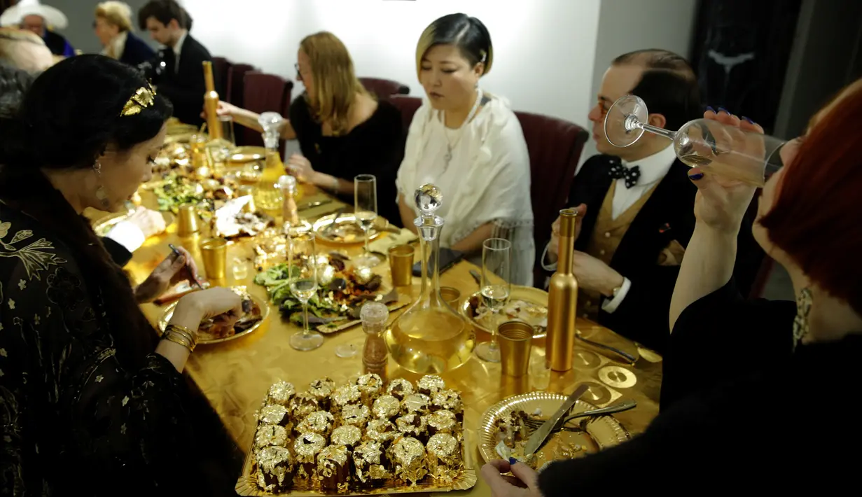 Para tamu menghadiri acara makan malam bernuasa emas 24 karat di Paris, Prancis, 28 Maret 2019. Makan malam tersebut disajikan oleh seniman Prancis, Frederique Lecerf. (REUTERS/Philippe Wojazer)