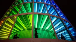 Pengunjung menikmati instalasi cahaya 'Spectra' di Festival Musik dan Seni Coachella di Indio, California, Amerika Serikat, Minggu (15/4). (AFP PHOTO/Kyle Grillot)