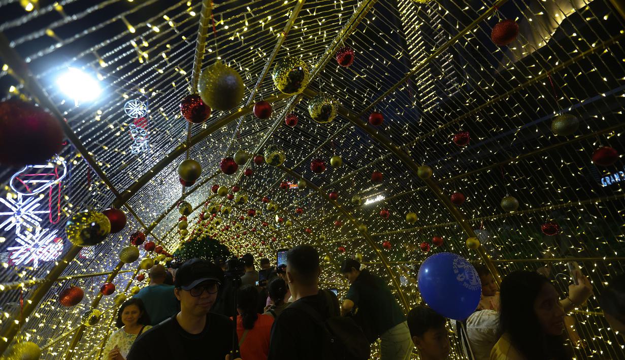 Gemerlap dari lampu-lampu ini tidak hanya berfungsi sebagai penerangan, tetapi disusun untuk menjadi ornamen Natal yang bisa dijadikan spot berfoto atau jalan-jalan santai. Tampak dalam foto, warga menikmati suasana Jakarta Light Festival 2025 di sekitar Bundara Hotel Indonesia, Jakarta, Selasa (23/12/2025). (Kapanlagi.com/Budy Santoso)