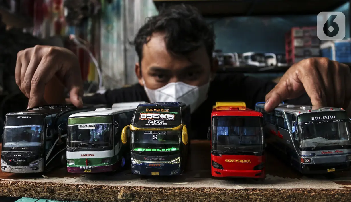 Perajin memamerkan miniatur bus di Workshop Belang Bentong, Limo, Depok, Jawa Barat, Jumat (14/1/2022). Kerajinan miniatur bus berbahan baku akrilik dan resin tersebut dipasarkan ke berbagai daerah dengan harga Rp 700 ribu hingga Rp 1 juta per unit. (Liputan6.com/Johan Tallo)