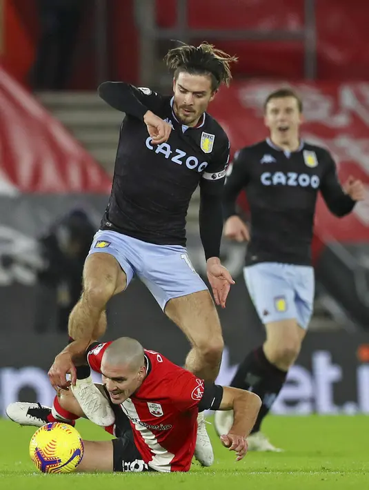 Pemain Aston Villa Jack Grealish (atas) berebut bola dengan pemain Southampton Oriol Romeu pada pertandingan Liga Inggris di Stadion St. Mary, Southampton, Inggris, Sabtu (30/1/2021). Aston Villa menang 1-0. (Michael Steele/Pool via AP)