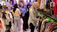 Para calon pembeli memilih pakaian impor bekas di Pasar Senen, Jakarta, Kamis (9/3/2023). Larangan impor baju bekas tercantum dalam Peraturan Menteri Perdagangan (Permendag) No.18/2021 tentang Barang Dilarang Ekspor dan Barang Dilarang Impor. (Liputan6.com/Faizal Fanani)