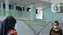 Petugas menyiapkan tempat singgah sementara bagi warga yang baru kembali ke Jakarta di GOR Cipayung, Jakarta, Selasa (18/5/2021). GOR ini jadi tempat singgah bagi mereka yang tidak memiliki tempat layak untuk isolasi mandiri sambil menunggu hasil tes swab antigen/PCR. (Liputan6.com/Herman Zakharia)