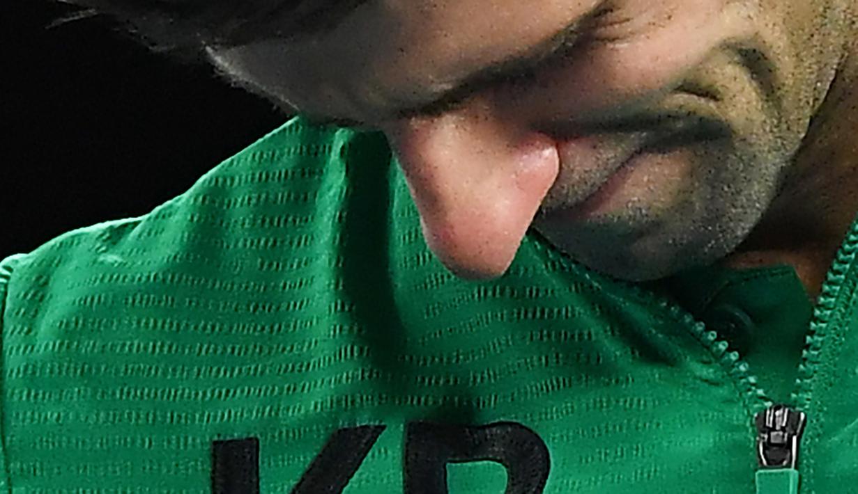 Petenis Serbia, Novak Djokovic, menangis saat diwawancara tentang Kobe Bryant seusai laga Australia Open 2020 di Melbourne, Selasa (28/1). Beri penghormatan dirinya memakai jaket inisial Kobe Bryant. (AFP/Greg Wood)