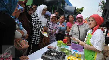 Sejumlah ibu-ibu melihat juru masak membuat jajanan tradisional di Pasar Pondok Labu, Jakarta Selatan (10/09). Acara yang diusung Gulaku untuk melestarikan jajanan tradisional Indonesia. (Liputan6.com/Gempur M Surya). 