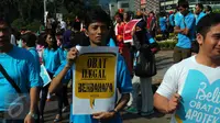 Peserta parade bersama BPOM membawa papan pesan saat kampanye anti obat ilegal di arena Car Free Day, Bundaran HI Jakarta, Minggu (21/8). Mereka memperingatkan warga untuk waspada terhadap penggunaan obat palsu tanpa izin edar. (Liputan6.com/Angga Yuniar)