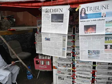 Seorang pedagang minum teh sambil membaca koran pagi di sebuah warung pinggir jalan di Islamabad, Pakistan, pada Rabu 8 April 2026. Perdana Menteri Pakistan, Shehbaz Sharif, pada Rabu 8 April 2026 mengatakan, Amerika Serikat (AS), Iran, dan sekutu mereka telah menyetujui gencatan senjata. (Aamir QURESHI/AFP)